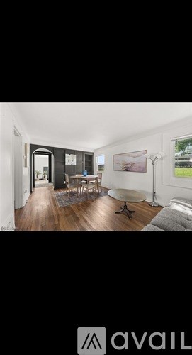 A living room with a couch, chairs, and a painting on the wall.