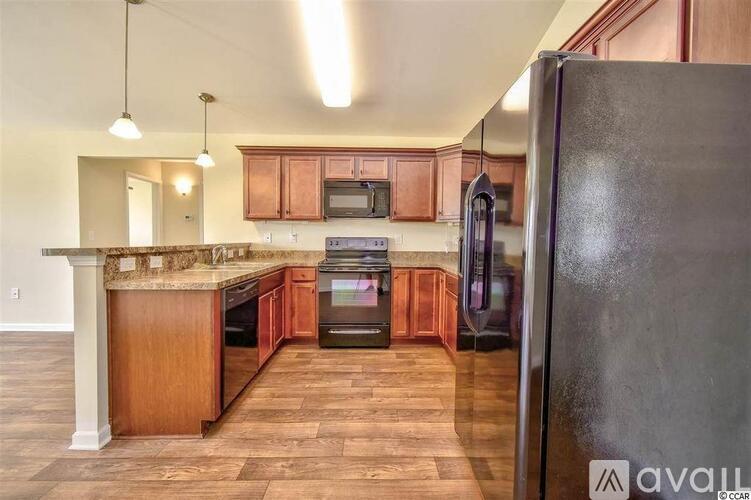 A kitchen with wooden cabinets and a black refrigerator.