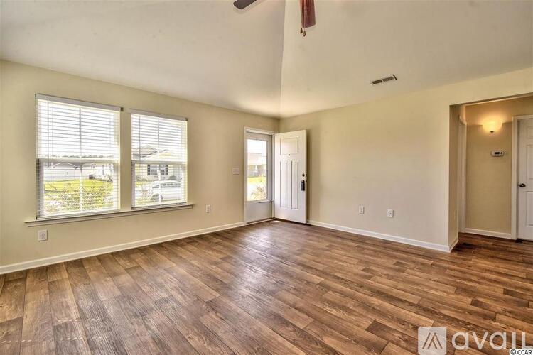 A room with wooden flooring and a ceiling fan.