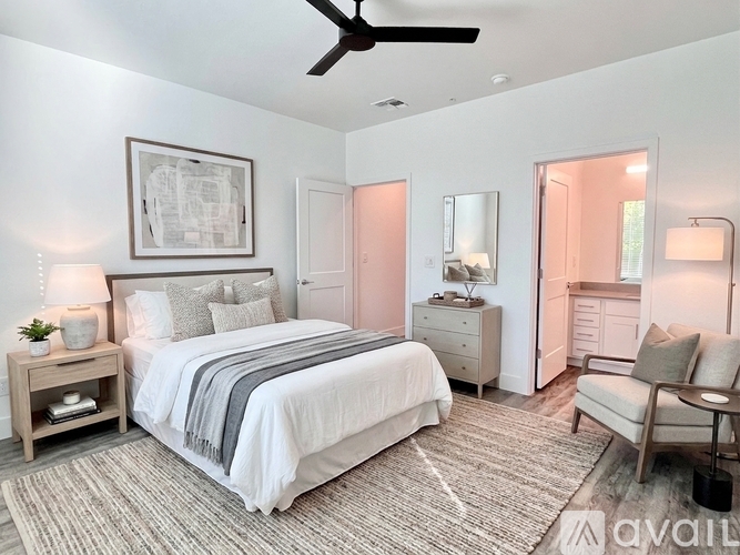 A bedroom with a bed, nightstand, and chair.