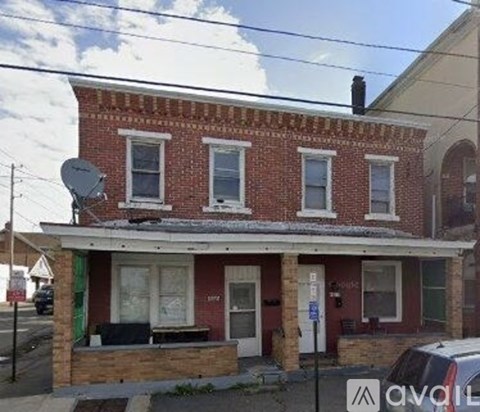 A red brick building with a satellite dish on the roof.