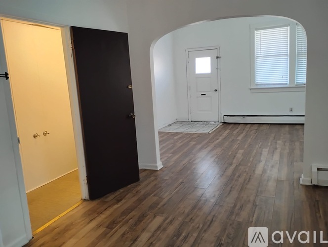 A room with wooden flooring and a white door.