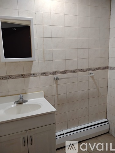 A bathroom with a white sink and a window above it.