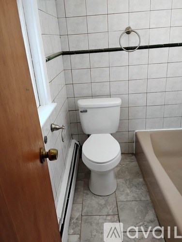 A white toilet sits next to a bathtub in a bathroom.