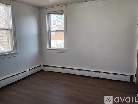A room with a window and wooden flooring.
