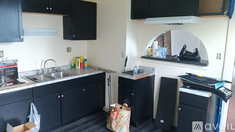 A kitchen with black cabinets and a white countertop.