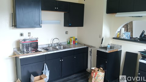 A kitchen with black cabinets and a white countertop.