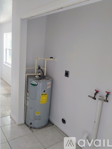 A water heater is installed in a corner of a room.