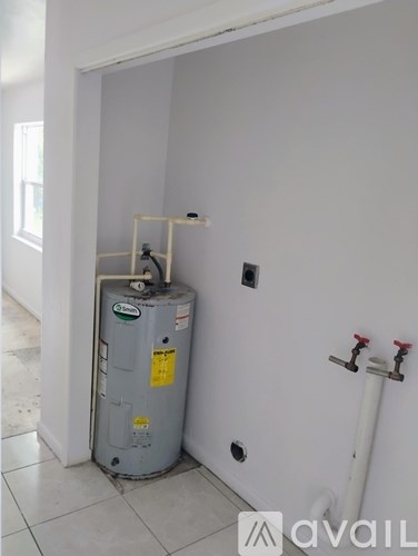 A water heater is installed in a corner of a room.