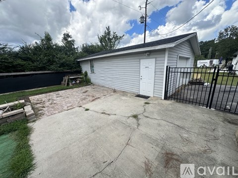 A small white building with a black fence in front of it.