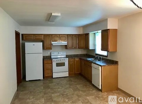 A kitchen with white appliances and brown cabinets.