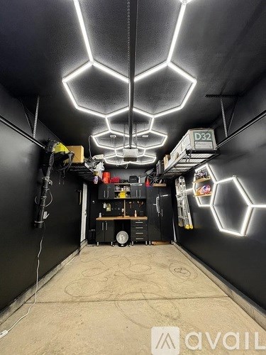 A room with hexagonal neon lights on the ceiling and a sign that says "D32" on the wall.