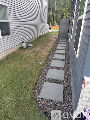 A grey house with a grey stone pathway in front.