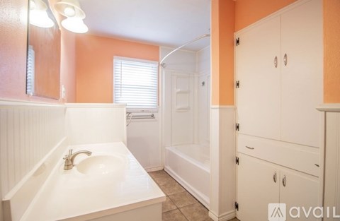 A bathroom with orange walls and a white sink.