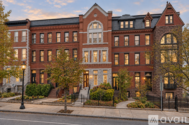 A large red brick building with a black fence in front.