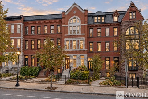 A large red brick building with a black fence in front.