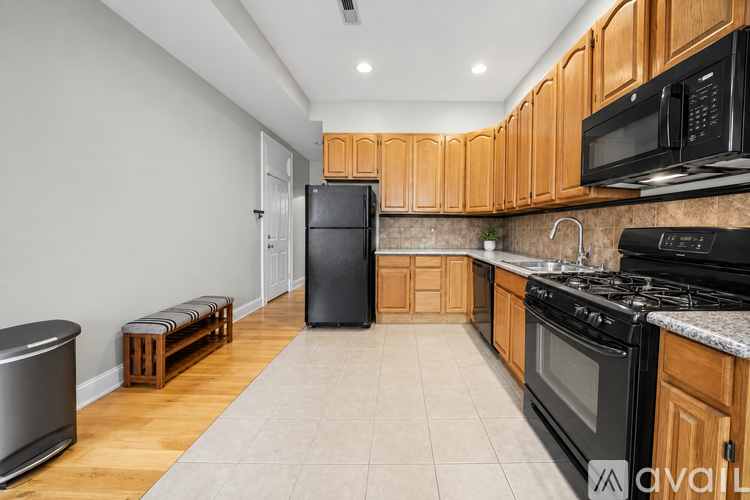 A kitchen with wooden cabinets and black appliances.