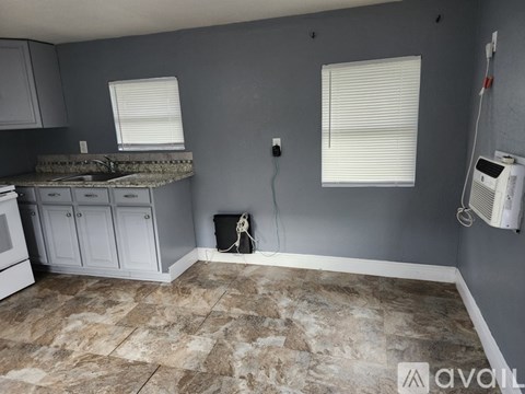 A kitchen with a granite countertop and a tile floor.