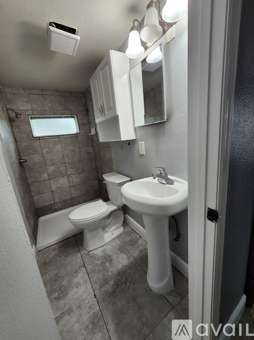 A bathroom with a toilet, sink, and mirror.