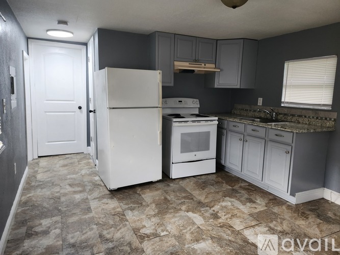 A kitchen with a white refrigerator, stove, and oven.
