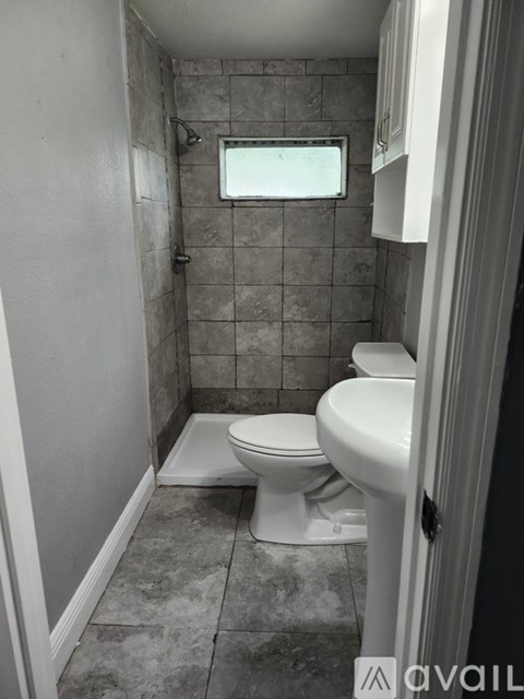 A bathroom with a toilet and a window.