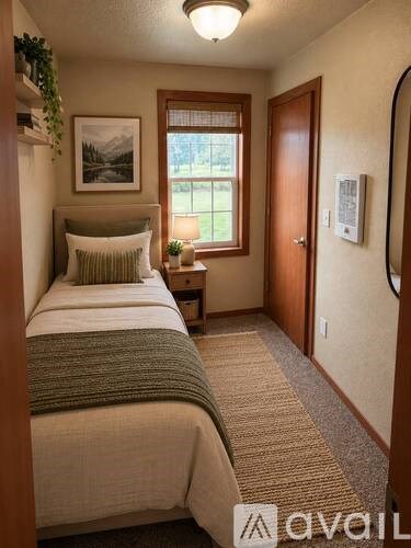 A bedroom with a bed, nightstand, and window.