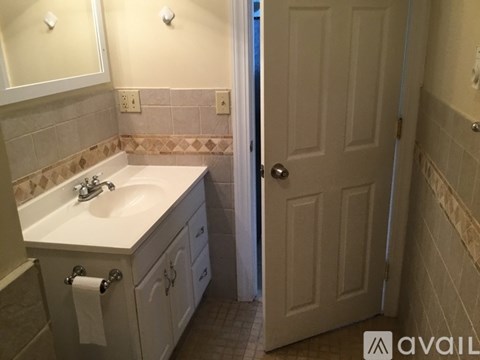A bathroom with a sink, mirror, and tiled walls.