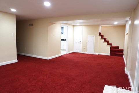 A room with red carpet and a staircase.