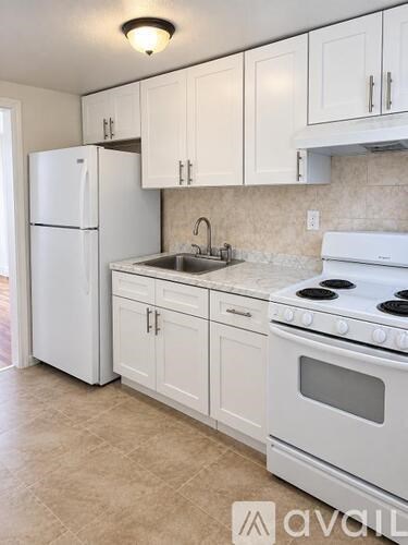 A kitchen with white appliances and cabinets.