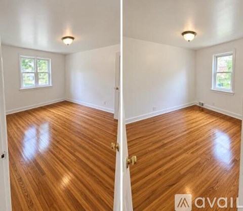 A room with wooden floors and two windows.