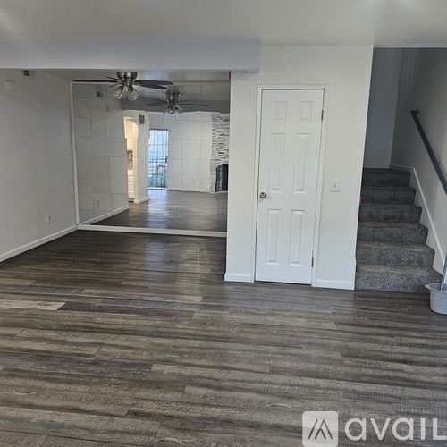 A room with a white door and a fan on the ceiling.
