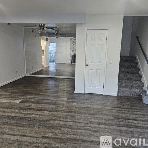 A room with a white door and a fan on the ceiling.