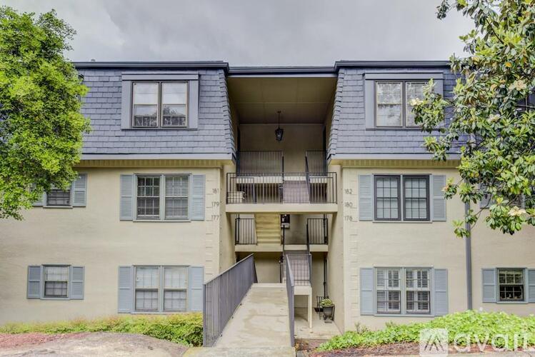 A two-story apartment building with a balcony on the second floor.