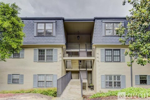 A two-story apartment building with a balcony on the second floor.