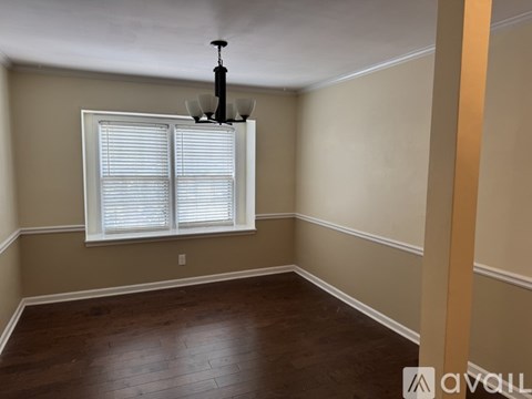 A room with a window and a chandelier.