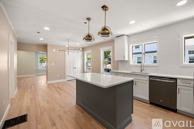 A modern kitchen with a large island and pendant lights.