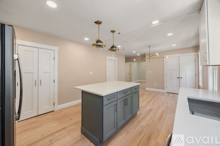 A kitchen with a white countertop and wooden floors.
