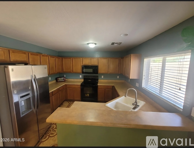 A kitchen with a refrigerator, sink, and oven.