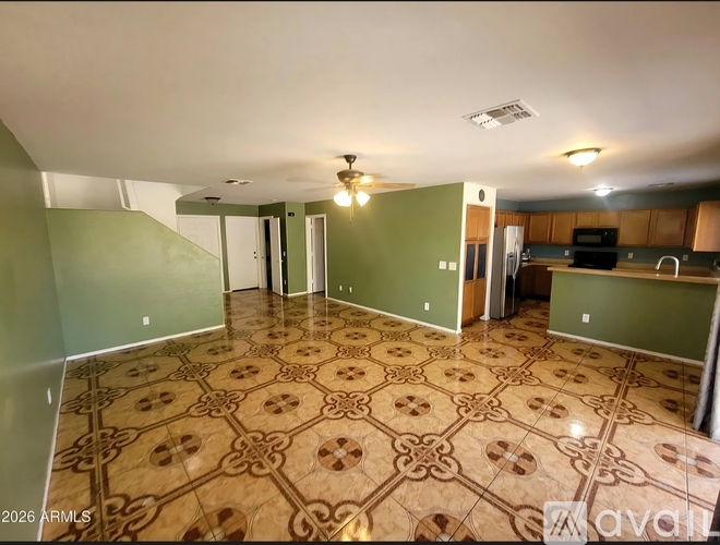 A large open room with a patterned floor and green walls.