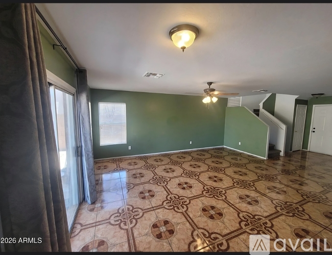 A room with a patterned floor and a ceiling fan.