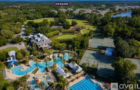 An aerial view of a resort with a swimming pool and tennis court.