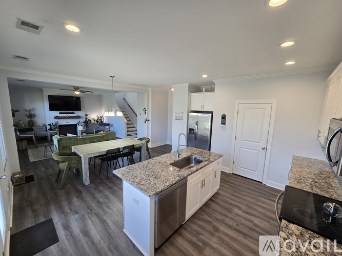 A kitchen with a dining table and chairs is visible.