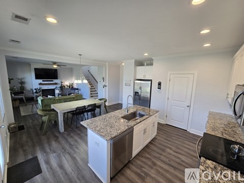 A kitchen with a dining table and chairs is visible.