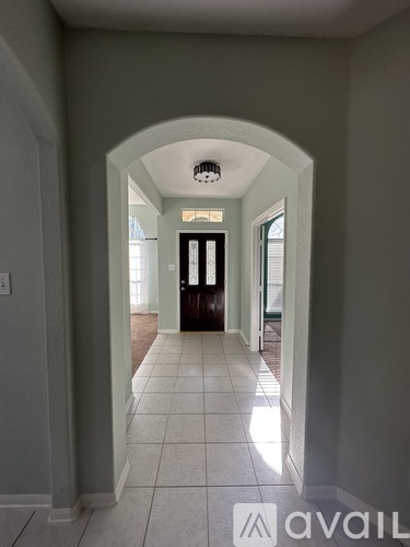 A hallway with a light on the ceiling and a door at the end.