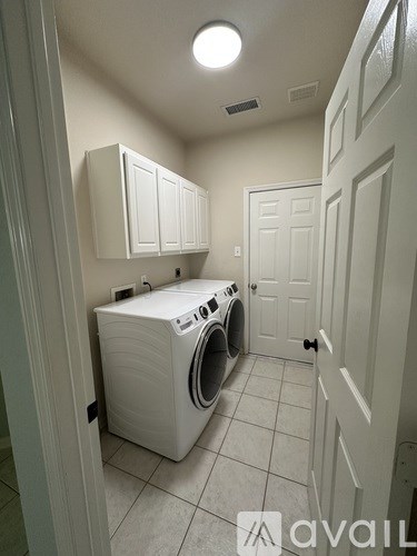 A small laundry room with a washer and dryer.