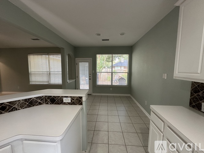 A kitchen with white cabinets and a countertop.