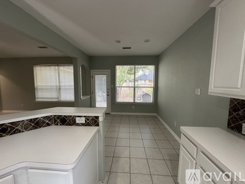 A kitchen with white cabinets and a countertop.