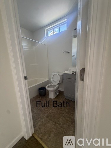A bathroom with a toilet and a bucket.