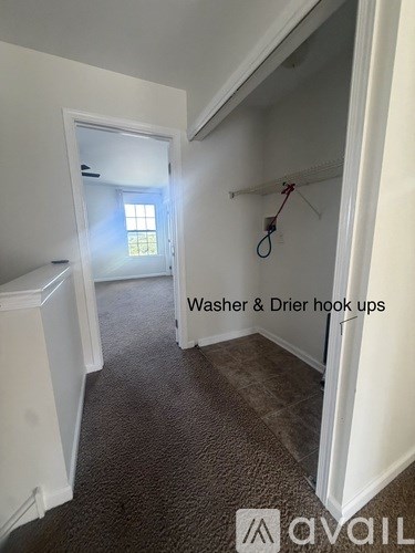 A room with a carpeted floor and a window.