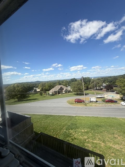 A view from a window looking out at a parking lot and a building.